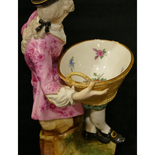 65 - A Meissen porcelain figure of a seated gentleman holding an oval basket (1 hand and thumb restored, ... 