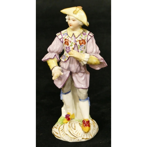 67 - A Meissen figure of a standing gentleman in puce jacket (plume to hat missing, chip to back of hat, ... 