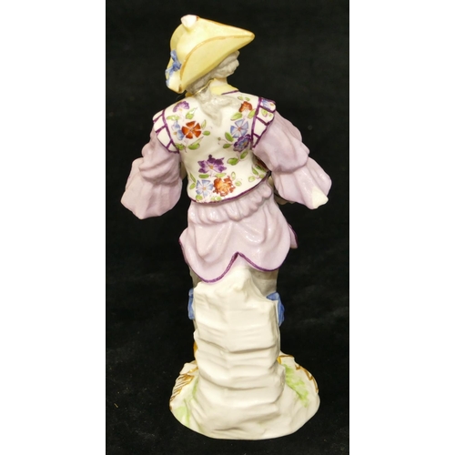 67 - A Meissen figure of a standing gentleman in puce jacket (plume to hat missing, chip to back of hat, ... 