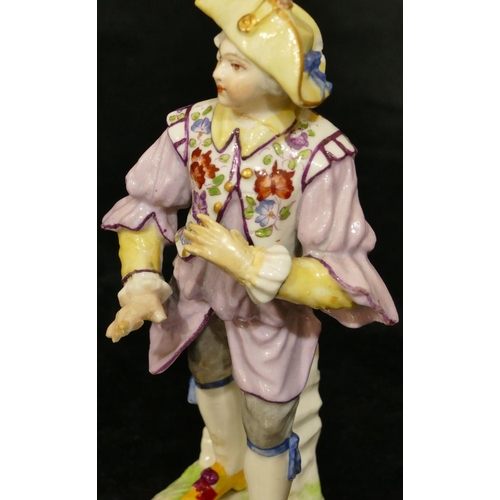 67 - A Meissen figure of a standing gentleman in puce jacket (plume to hat missing, chip to back of hat, ... 