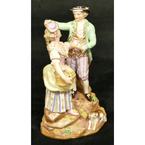 69 - A Meissen porcelain group of standing gentleman and lady holding a basket of encrusted flowers, dog ... 