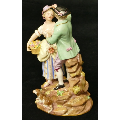 69 - A Meissen porcelain group of standing gentleman and lady holding a basket of encrusted flowers, dog ... 