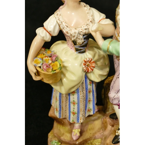 69 - A Meissen porcelain group of standing gentleman and lady holding a basket of encrusted flowers, dog ... 