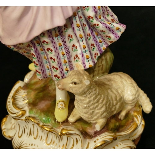 72 - A Meissen figure of a standing lady with sheep at her feet (part tree stump, lamb's left hoof and le... 