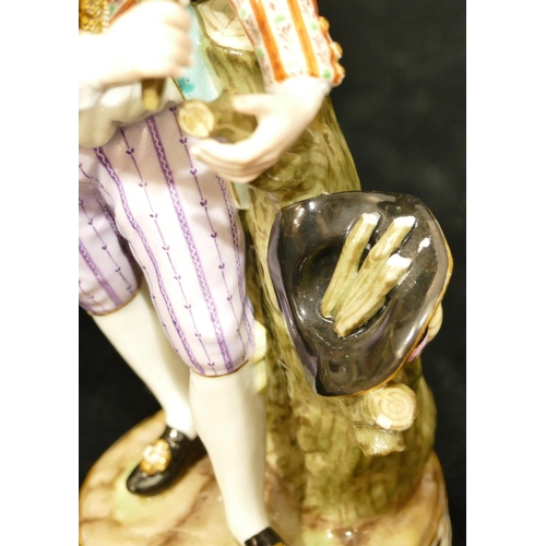 73 - A Meissen figure of a standing gentleman gathering twigs in his hat (ends of sticks in hat chipped) ... 