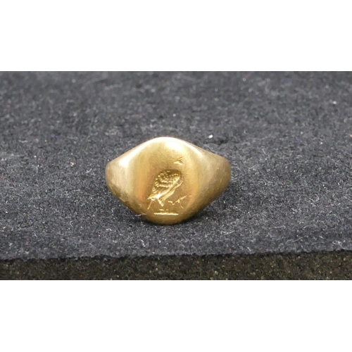 732 - A high carat gold signet ring with part engraved crest, size M/N, 7.2 grams