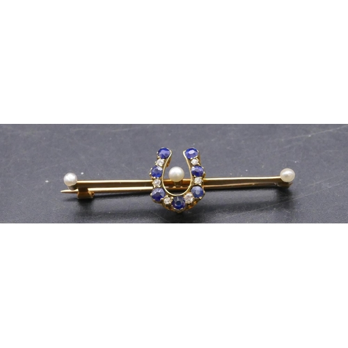 733 - A 15ct gold bar brooch with horseshoe centre inset with 7 sapphires and interspersed by 6 small diam... 