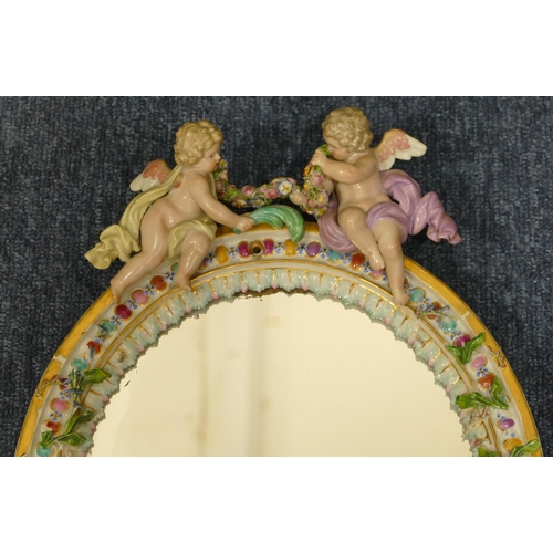 74 - A Meissen oval hanging and freestanding dressing table mirror with 2 raised Cupids with allover encr... 