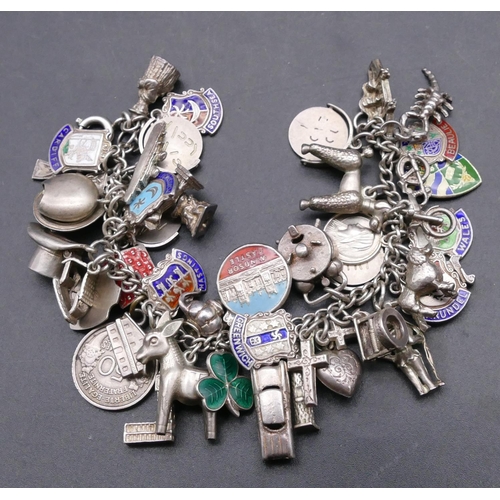 740 - A silver bracelet mounted with 47 silver and enamelled charms, 76.6 grams