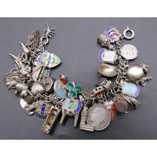 740 - A silver bracelet mounted with 47 silver and enamelled charms, 76.6 grams