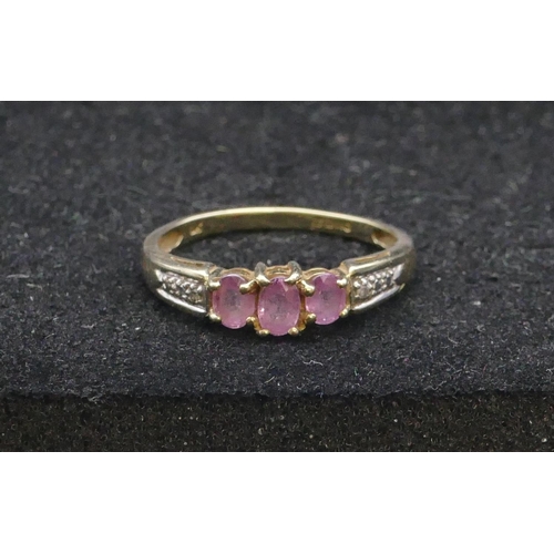 744 - A 9ct gold ladies' ring set with 3 centre pink stones, flanked by diamond chips, size Q, 2 grams gro... 