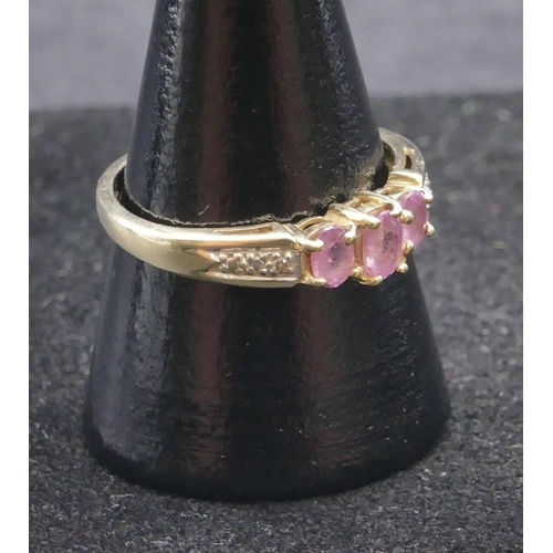 744 - A 9ct gold ladies' ring set with 3 centre pink stones, flanked by diamond chips, size Q, 2 grams gro... 