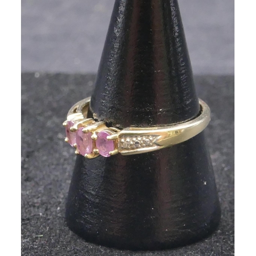 744 - A 9ct gold ladies' ring set with 3 centre pink stones, flanked by diamond chips, size Q, 2 grams gro... 