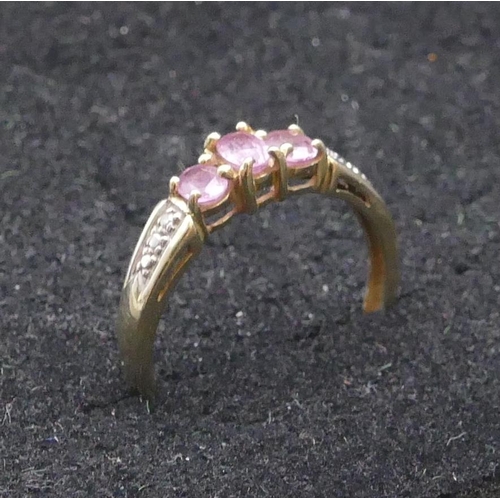 744 - A 9ct gold ladies' ring set with 3 centre pink stones, flanked by diamond chips, size Q, 2 grams gro... 