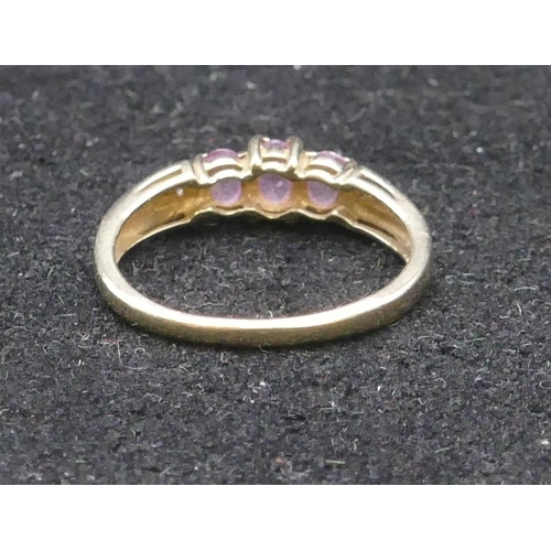 744 - A 9ct gold ladies' ring set with 3 centre pink stones, flanked by diamond chips, size Q, 2 grams gro... 