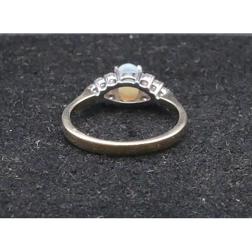 749 - A 9ct gold ladies' ring set with oval opal flanked by 12 diamonds, size O/P, 2.3 grams gross