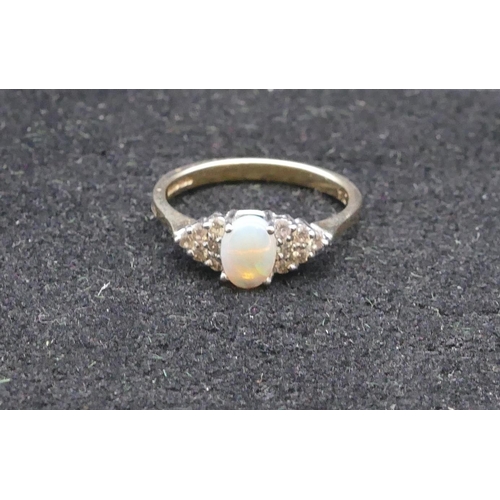 749 - A 9ct gold ladies' ring set with oval opal flanked by 12 diamonds, size O/P, 2.3 grams gross