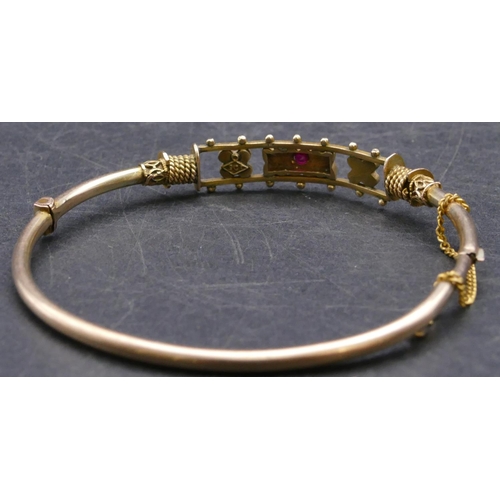 756 - A 9ct gold bangle set with centre red stone and half pearls (clasp in need of restoration), 7.5 gram... 