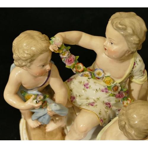 76 - A Meissen group of 4 seated children (1 right foot, 1 part left foot missing, chip to encrusted bask... 