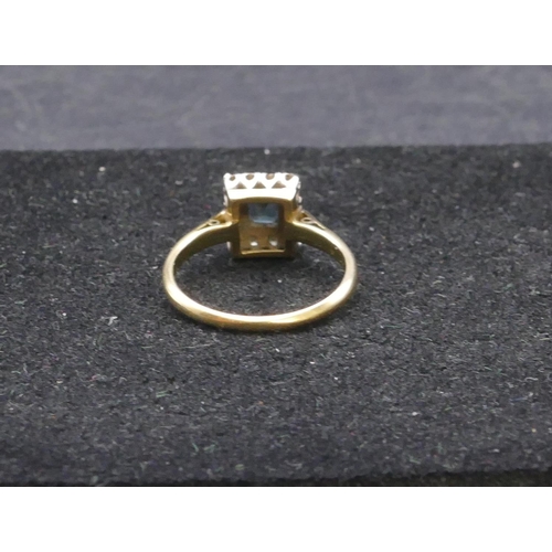 760 - An 18ct gold ladies' rectangular shaped ring set with centre sapphire surrounded by small diamond ch... 