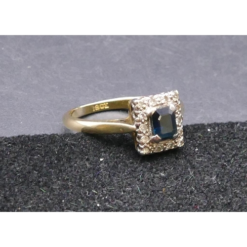 760 - An 18ct gold ladies' rectangular shaped ring set with centre sapphire surrounded by small diamond ch... 