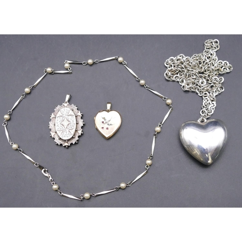 764 - A silver oval drop pendant, a 9ct gold front and back heart shaped locket with hinged front and a la... 