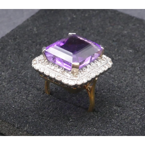 783 - An 18ct gold rectangular shaped ladies' large cluster ring set with centre amethyst surrounded by 2 ... 