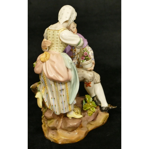 79 - A Meissen group of seated gentleman holding encrusted plant with standing lady (2 chips to branches ... 