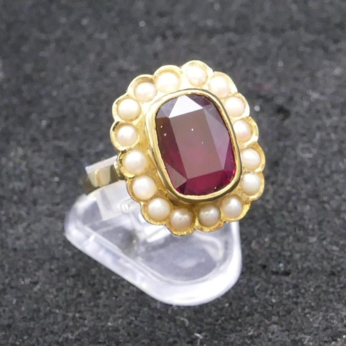 805 - An 18ct gold ladies' ring set with centre red stone surrounded by half pearls, size M/N, 6 grams gro... 