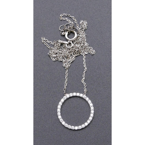 812 - A 925 silver pendant in form of a circle and mounted with clear stones, with chain.