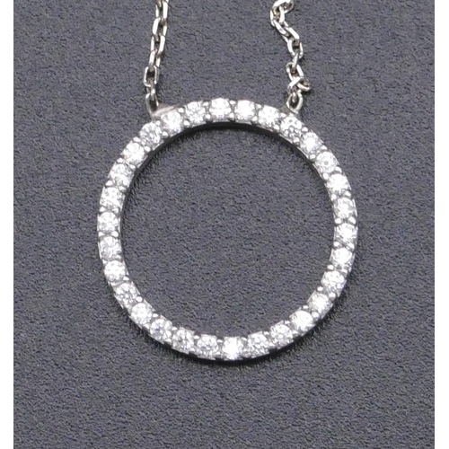 812 - A 925 silver pendant in form of a circle and mounted with clear stones, with chain.