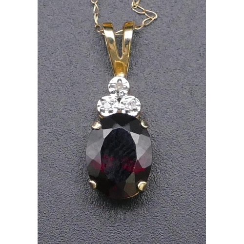 814 - A 9ct gold drop pendant set with garnet and 3 small diamonds, with chain, 1.4 grams gross.