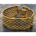 An 18ct 3-coloured gold wide band bracelet with pierced decoration, stamped 750, 19cm long, 66.9 gra... 