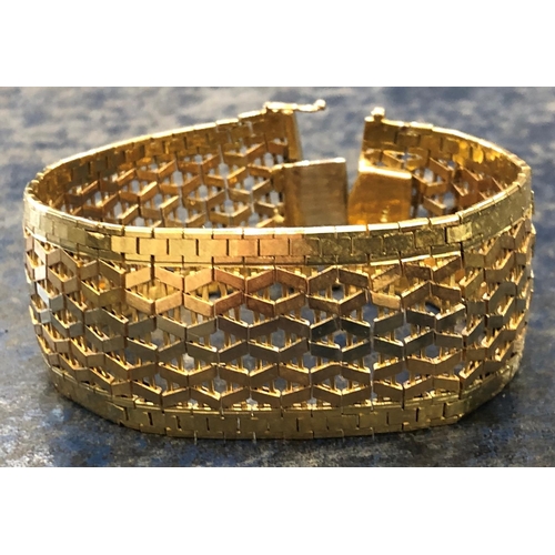 822 - An 18ct 3-coloured gold wide band bracelet with pierced decoration, stamped 750, 19cm long, 66.9 gra... 