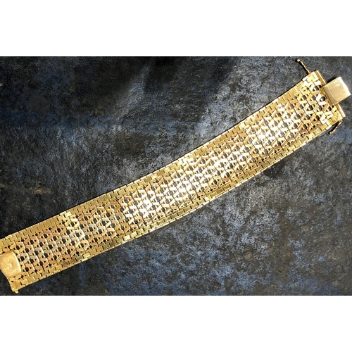822 - An 18ct 3-coloured gold wide band bracelet with pierced decoration, stamped 750, 19cm long, 66.9 gra... 