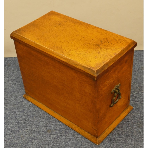 829 - An oak stationery box with hinged top and drop front enclosing stationery rack, pen drawer etc, bras... 