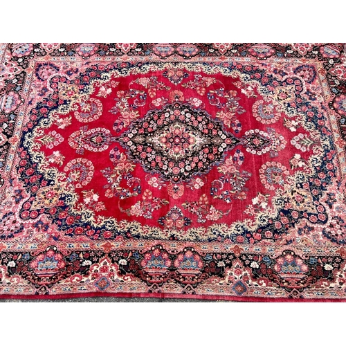 981 - A Persian carpet on red and blue ground having centre medallion 397 x 270cm