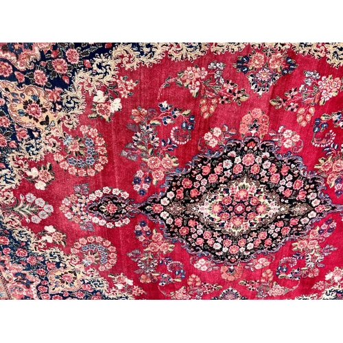 981 - A Persian carpet on red and blue ground having centre medallion 397 x 270cm