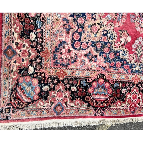 981 - A Persian carpet on red and blue ground having centre medallion 397 x 270cm