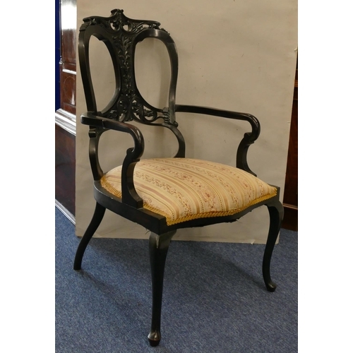 1166 - An ebonised armchair with pierced and raised carved floral, leaf and pierced decoration, floral over... 