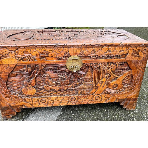 6145 - A camphor wood trunk with hinged lid and allover carved figure, landscape and floral decoration, 95 ... 