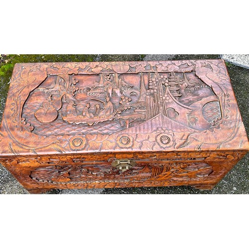 6145 - A camphor wood trunk with hinged lid and allover carved figure, landscape and floral decoration, 95 ... 