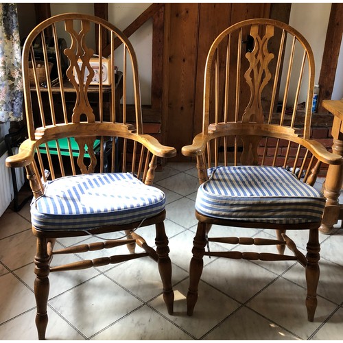 6138 - A pair of pine comb back Windsor armchairs, 119cm high, 65cm wide, with blue and white cushions (wor... 