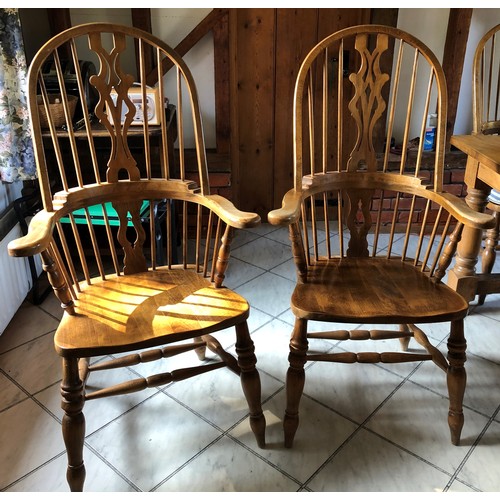 6138 - A pair of pine comb back Windsor armchairs, 119cm high, 65cm wide, with blue and white cushions (wor... 