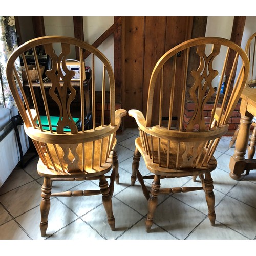 6138 - A pair of pine comb back Windsor armchairs, 119cm high, 65cm wide, with blue and white cushions (wor... 