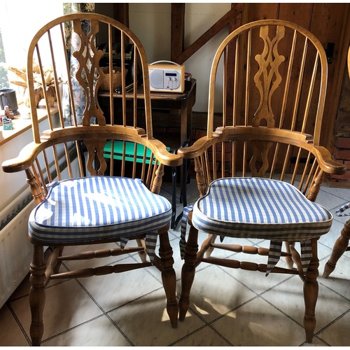 6139 - A pair of pine comb back Windsor armchairs, 119cm high, 65cm wide, with blue and white cushions (wor... 