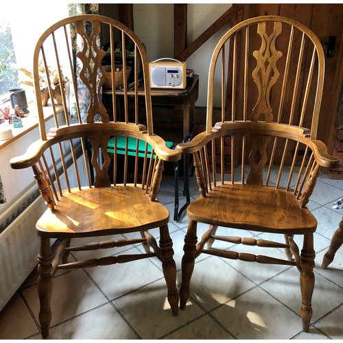 6139 - A pair of pine comb back Windsor armchairs, 119cm high, 65cm wide, with blue and white cushions (wor... 