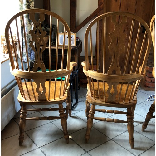 6139 - A pair of pine comb back Windsor armchairs, 119cm high, 65cm wide, with blue and white cushions (wor... 