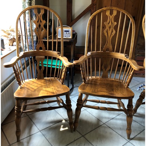 6141 - A pair of pine comb back Windsor armchairs, 119cm high, 65cm wide, with blue and white cushions (wor... 