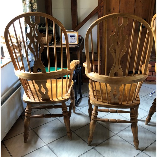 6141 - A pair of pine comb back Windsor armchairs, 119cm high, 65cm wide, with blue and white cushions (wor... 